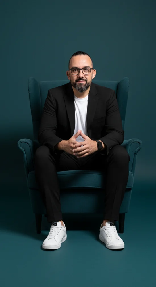 Homem sentado em cadeira azul, formal e casual.